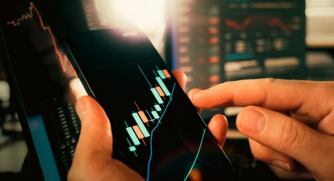 Person analyzing financial market data on the smartphone